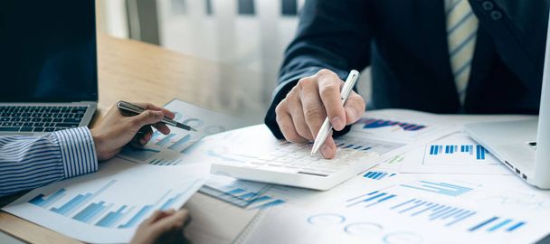 紙文書、口座、契約、投資コンサルタント、ラップトップと分析技術を使用した企業マーケティング計画に関する財務数値の作業と分析. - 写真・画像