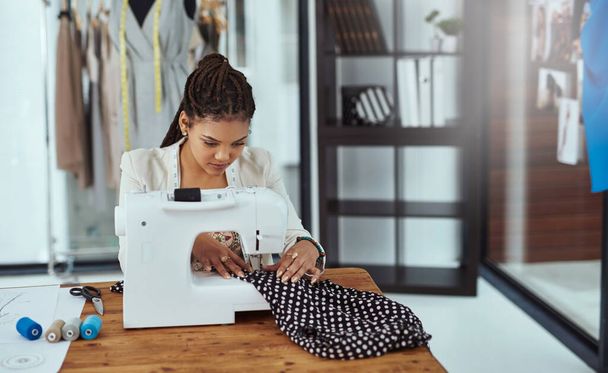 O ponto final. um designer de moda jovem usando uma máquina de costura em sua oficina - Foto, Imagem