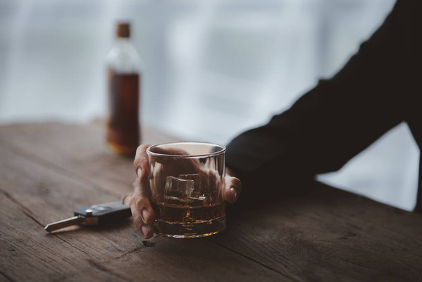 Mies, jolla on lasillinen brandyä, juo brandyä baarissa, juo alkoholia heikentää ajokykyä ja voi vahingoittaa terveyttä. Alkoholin käytön käsite. - Valokuva, kuva