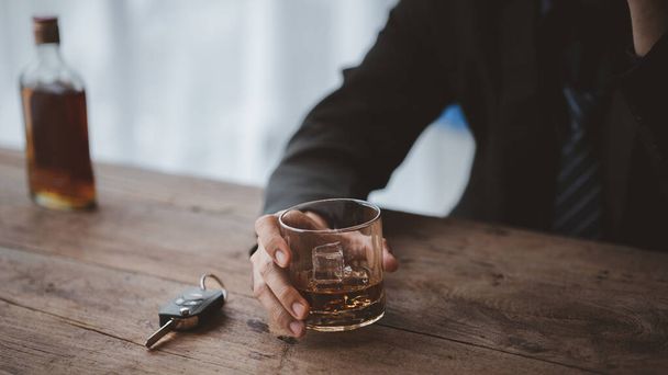Mies, jolla on lasillinen brandyä, juo brandyä baarissa, juo alkoholia heikentää ajokykyä ja voi vahingoittaa terveyttä. Alkoholin käytön käsite. - Valokuva, kuva