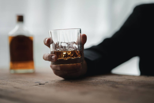 Muž drží sklenici brandy, pije brandy v baru, pije alkohol zhoršuje řidičské schopnosti a může poškodit zdraví. Koncept konzumace alkoholu. - Fotografie, Obrázek