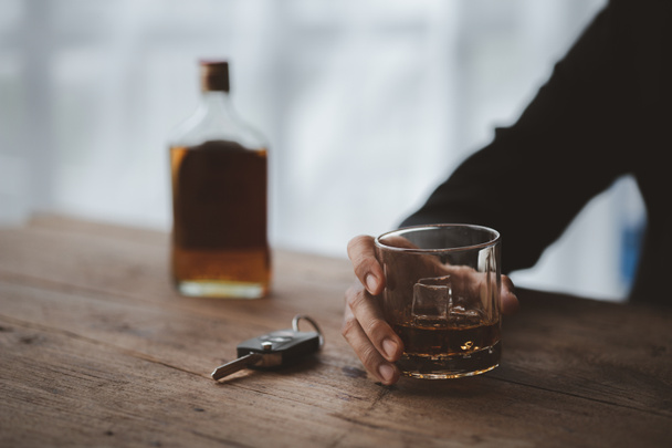 Muž drží sklenici brandy, pije brandy v baru, pije alkohol zhoršuje řidičské schopnosti a může poškodit zdraví. Koncept konzumace alkoholu. - Fotografie, Obrázek