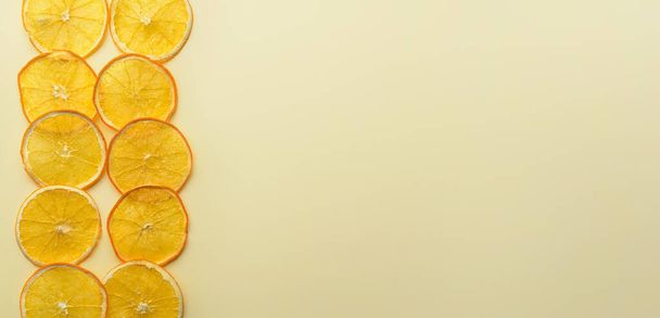 Bej arkaplanda birçok kurutulmuş portakal dilimleri metin ve üst görünüm için boşluk - Fotoğraf, Görsel