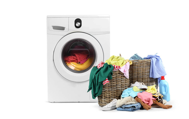Современная стиральная машина с грязной одеждой в корзине для белья на белом фоне - Фото, изображение