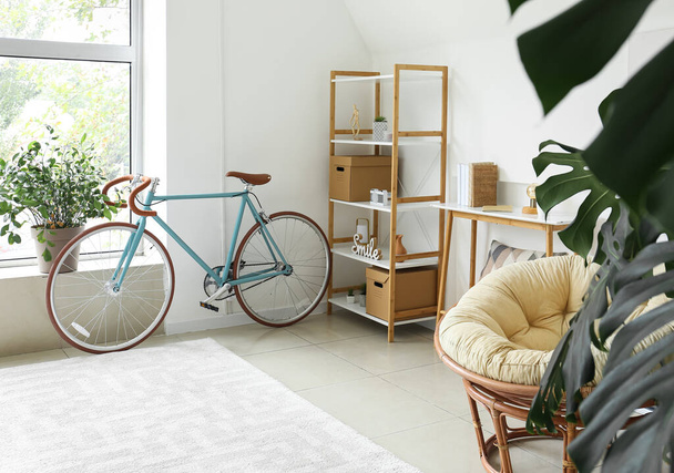 Interior of light living room with bicycle and shelving unit - Photo, Image