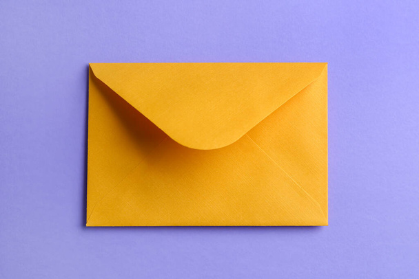 Leylak arkaplan üzerinde sarı kağıt zarf - Fotoğraf, Görsel