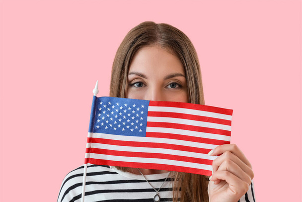 Kaunis nainen, jolla on Yhdysvaltain lippu vaaleanpunaisella taustalla, lähikuva - Valokuva, kuva