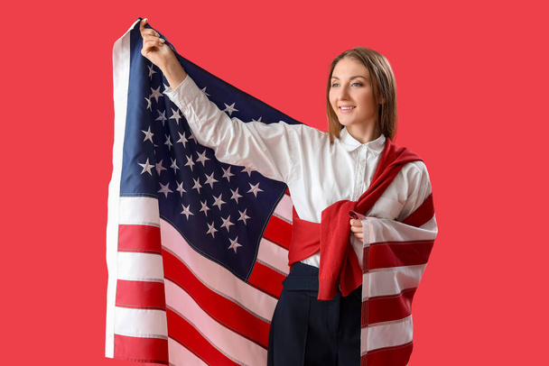 Kaunis nainen, jolla on Yhdysvaltain lippu punaisella taustalla - Valokuva, kuva