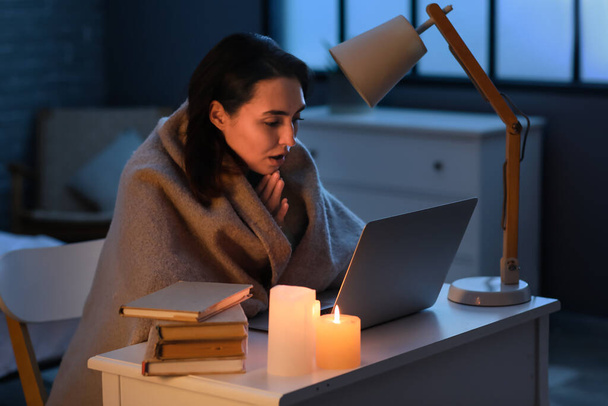 congelato giovane donna utilizzando il computer portatile a casa durante blackout - Foto, immagini
