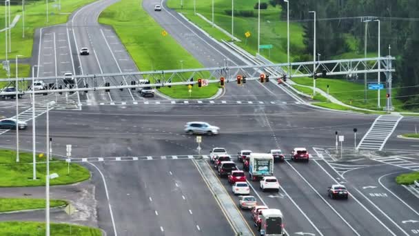 Luftaufnahme einer großen mehrspurigen Straßenkreuzung mit Ampeln und fahrenden Autos und Lastwagen. - Filmmaterial, Video