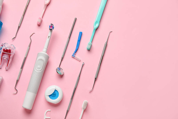 Herramientas dentales con cepillos de dientes sobre fondo rosa - Foto, Imagen