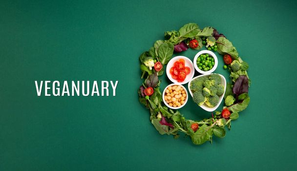 Вегетарианская и веганская диета месяц в январе называется Veganuary. Вареники вегана, растительная белковая пища, полезные сырые овощи. Вид сверху на зеленый фон. - Фото, изображение