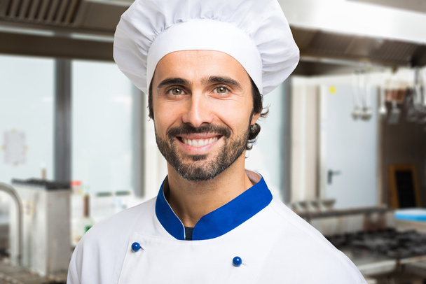 Smiling chef in kitchen - Фото, изображение