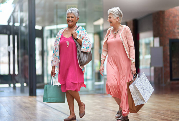 Πάμε στο επόμενο μαγαζί. Πλήρης εικόνα από δύο ηλικιωμένες γυναίκες έξω σε ένα ξεφάντωμα ψώνια - Φωτογραφία, εικόνα