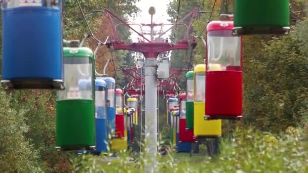 Barevné lanové dráhy v zábavním parku s podzimními barevnými stromy - Záběry, video