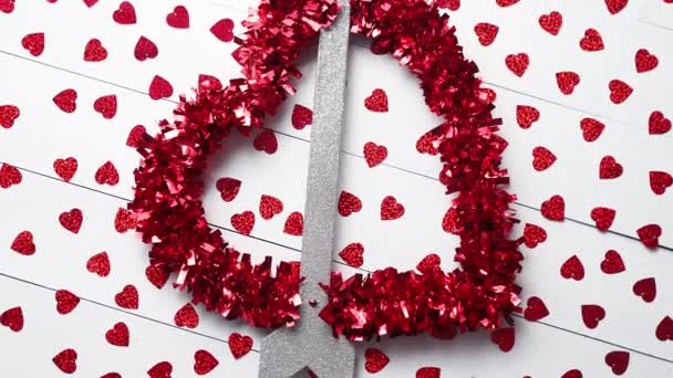 Ystävänpäivä sisustus koostumus. Sydän nuolella kuin rakkauden symboli sijoitettu taustalla punainen paljetteja valkoinen puinen pöytä. Romanttinen tausta. Tasainen, ylhäältä
. - Materiaali, video