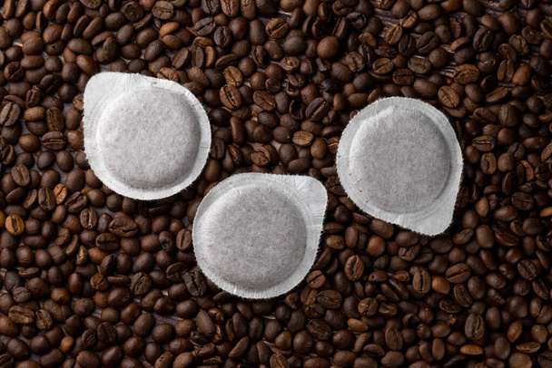 Kahvinkeittimen paperikapselit kahvipapujen taustalla - Valokuva, kuva