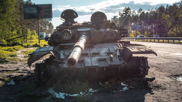 War in Ukraine, Kyiv region, Zhytomyr highway, a broken Russian tank stands near the highway, front view - Photo, Image