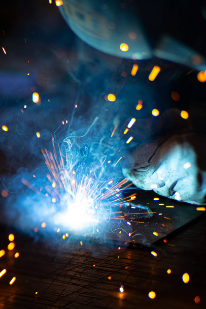 Soudeur de métaux travaille avec un soudeur d'acier dans une usine avec un équipement de protection. Fabrication de structures métalliques et services de réparation et de construction selon le concept de travail manuel. - Photo, image