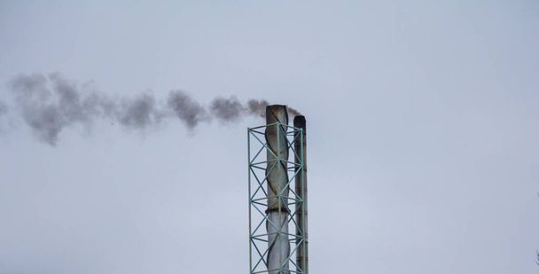 26.12.2022 Slovakia. Sala. Chimney of an old boiler room from which smoke comes out. - Foto, afbeelding