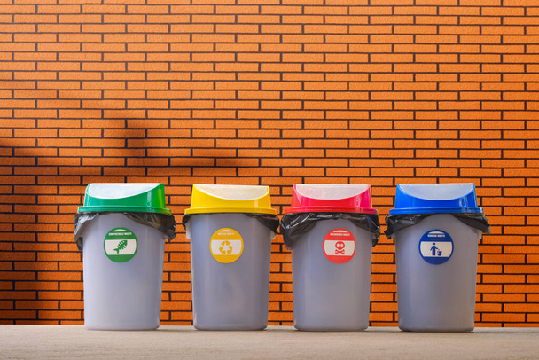 Multi Colored garbage bins on pavement with blurred artificial brick wall background - Photo, Image