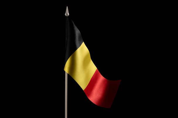 Bandera nacional pequeña de Bélgica sobre fondo negro. Aislar - Foto, imagen