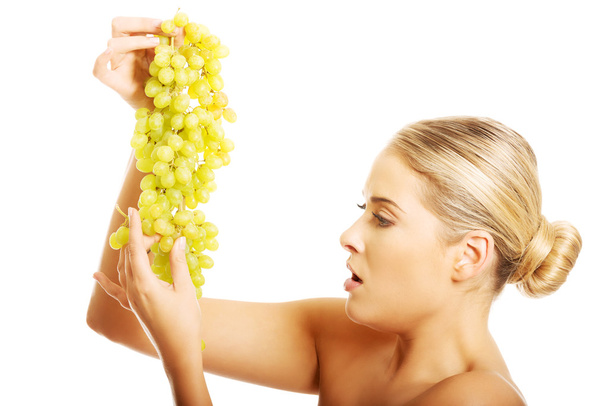Nude woman holding grapes - Foto, Imagen