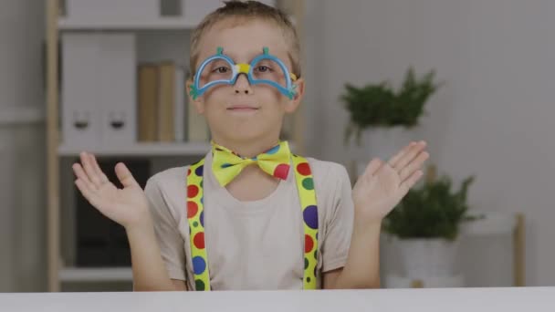 Jongen van 9 jaar gekleed in clown jurk en maakt wat grimas. Hoge kwaliteit 4k beeldmateriaal - Video