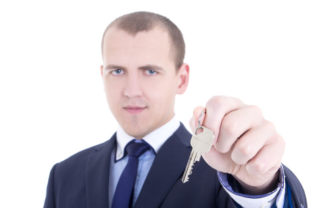 metal llave en mano de hombre inmobiliaria aislado en blanco - Foto, imagen