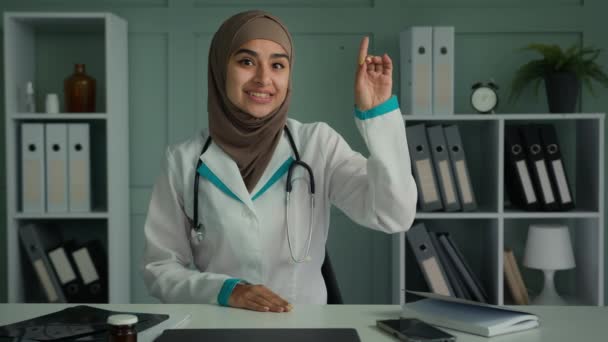 Webcam vista araba donna in hijab giovane medico generico medico femminile parlando lontano videochiamata uso computer conferenza app spiegare le regole mediche avvertono sulla pandemia di virus consultazione online - Filmati, video