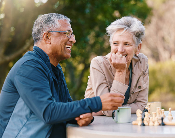 Happy, chess or couple of friends in nature playing a board game, bonding or talking about a funny story. Park, support or healthy senior people laughing at a joke and enjoying quality relaxing time. - Photo, Image