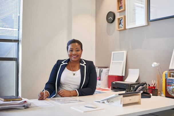Zakelijk slim met een glimlach. Portret van een zakenvrouw aan haar bureau in een kantoor - Foto, afbeelding