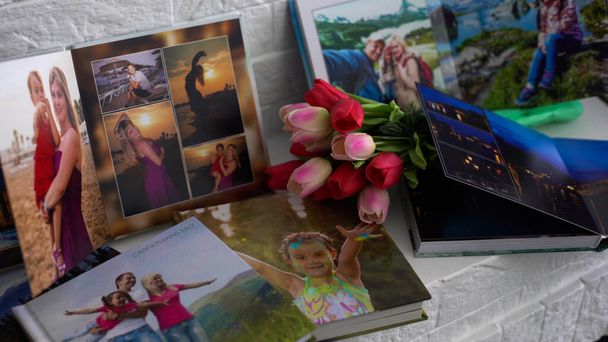 fotoboek en bloemen tulpen als vakantiecadeau liggen op de plank. - Foto, afbeelding