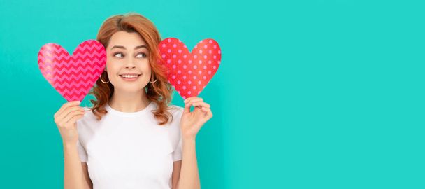 positive young lady with red heart on blue background. Woman isolated face portrait, banner with mock up copyspace - Photo, Image