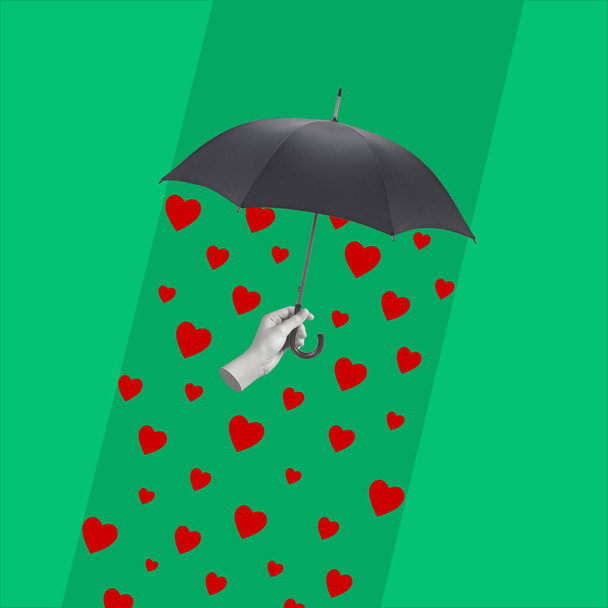 Die Hand hält einen Regenschirm und es regnet von Herzen. Collage zeitgenössischer Kunst. Urlaub und Liebe Konzepte. Grußkarte vorhanden. Kopierraum für Werbung. - Foto, Bild