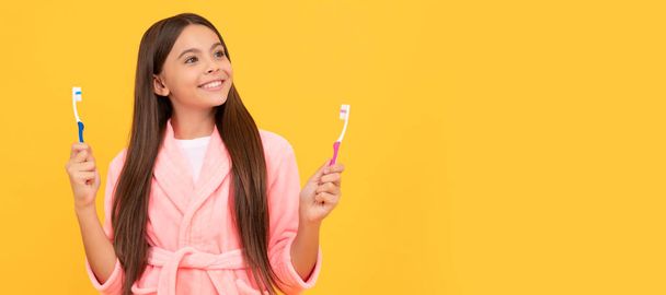 мечтательная счастливая девочка-подросток в доме махровый халат держать зубную щетку, здоровье. Знамя девочки с зубной щеткой, студийный портрет, заголовок с копировальным пространством - Фото, изображение