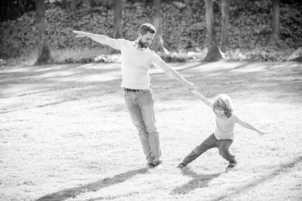 Onnellinen poika lapsi vetää isät käsi leikkii kesällä ulkona, hauskaa. - Valokuva, kuva
