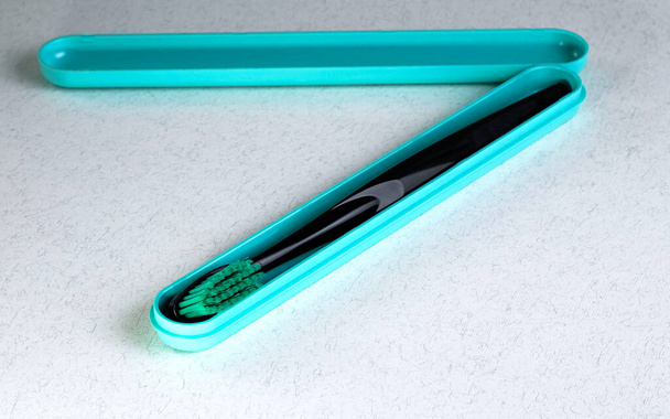 Cepillo de dientes negro en una caja abierta azul - Foto, Imagen