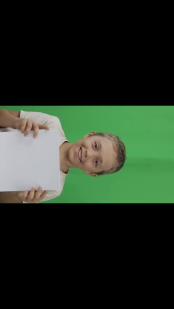 Boy of 9 years holds a sheet of paper. Closeup. High quality footage - Imágenes, Vídeo
