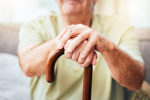 Hombre de edad avanzada, manos y bastón para caminar por discapacidad o vejez, retiro y hogar de ancianos con cuidado de personas mayores. Anciano relajarse con bastón de madera para caminar apoyo, osteoporosis y artritis - Foto, imagen