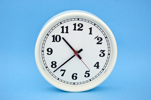white clock dial  on blue background - Foto, afbeelding