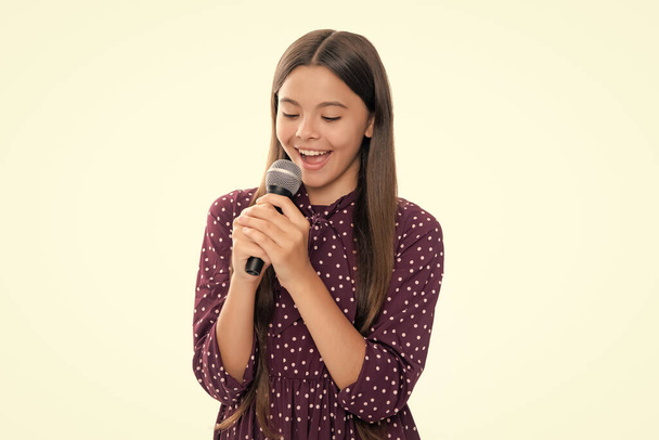 Aranyos lány egy mikrofonnal és egy dalt énekel. Az énekes lány karaokézik. - Fotó, kép