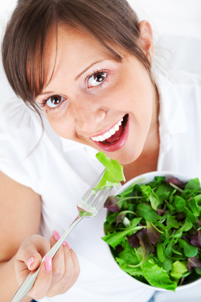молодая женщина ест салат - Фото, изображение