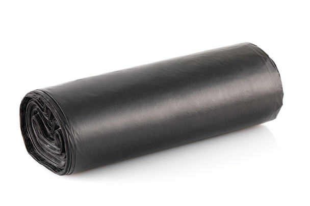 Roll of black plastic garbage bags isolated on white background. Full depth of field. Closeup - Foto, Imagen