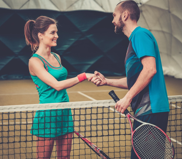 Mulher jogador de tênis apertando a mão com seu treinador
 - Foto, Imagem