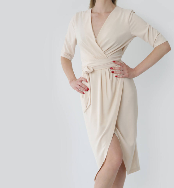 Студійний знімок жінки в стильній простій бежевій віскозній літній сукні
. - Фото, зображення