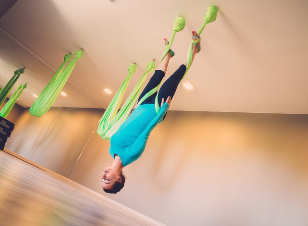 Mladá žena provádějící protigravitační jóga cvičení - Fotografie, Obrázek
