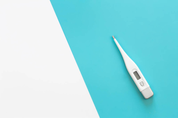 Electronic thermometer on a colored background, flat lay, copy space. - Photo, image