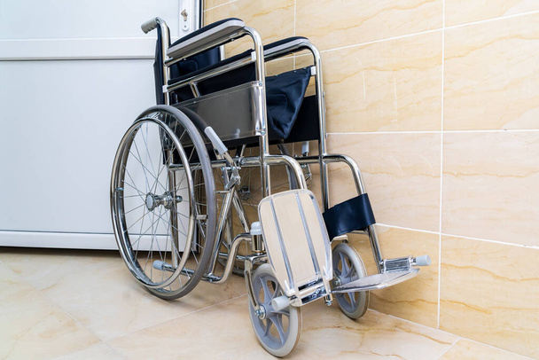 Összecsukható kerekesszék speciális igényű vagy fogyatékossággal élő emberek számára, szelektív fókusszal és homályos háttérrel, tónusú. Egészségügy és gyógyszerek. - Fotó, kép