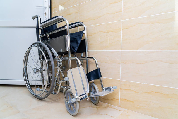 Folding wheelchair for people with special needs or disabilities with selective focus and blurry background, toned. Health and medicine. - Photo, Image